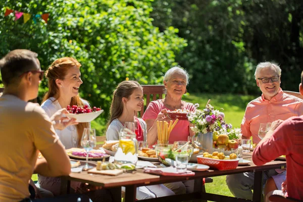 Mutlu bir aile yemek yiyor ya da bahçe partisi veriyor. — Stok fotoğraf