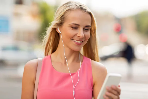 Feliz joven con teléfono inteligente y auriculares —  Fotos de Stock