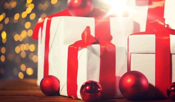 Cajas de regalo y bolas rojas en el suelo de madera — Foto de Stock