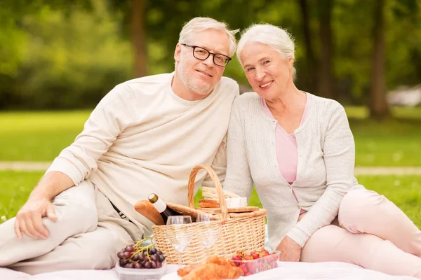 Happy senior couple having picnic at summer park — Stock Photo, Image