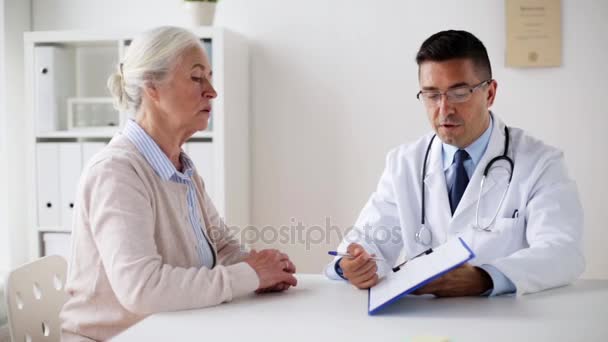 Пожилая женщина и врач с кардиограммой в клинике — стоковое видео