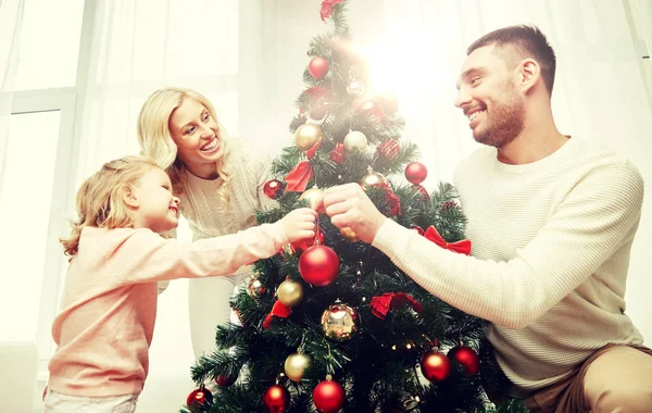 Счастливая семья украшая елку дома — стоковое фото