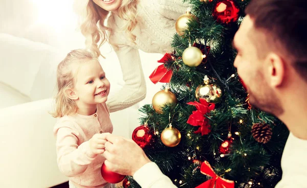 Happy family decorating christmas tree at home — Stock Photo, Image