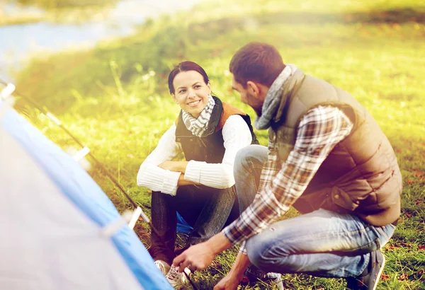 Happy couple setting up tent outdoors — Stock Photo, Image