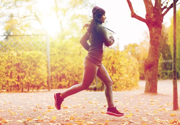 Primer plano de la joven corriendo en el parque de otoño — Foto de Stock