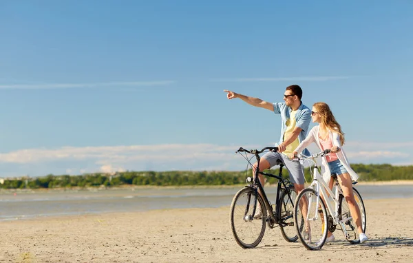Boldog fiatal pár kerékpárral a tengerparton — Stock Fotó