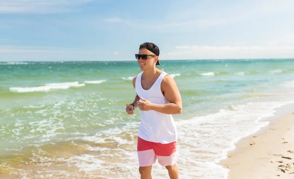 Glücklicher Mann läuft am Sommerstrand entlang — Stockfoto