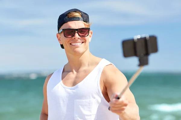 Homme avec smartphone selfie bâton sur la plage d'été — Photo