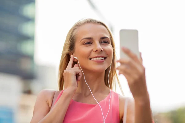 Feliz joven con teléfono inteligente y auriculares —  Fotos de Stock