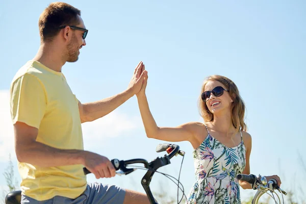 Lyckliga par med cyklar att göra high five — Stockfoto