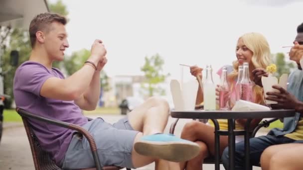 Mann fotografiert Freunde beim Essen auf Foodtruck — Stockvideo