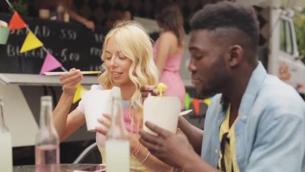 フード トラックで鍋を食べて幸せな人種カップル — ストック動画