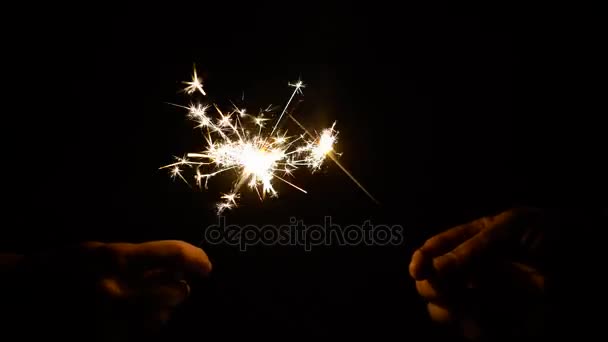 Hands with burning sparklers in darkness — Stock Video