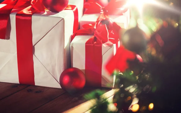 Hediye kutuları ve Noel ağacının altında kırmızı topları — Stok fotoğraf