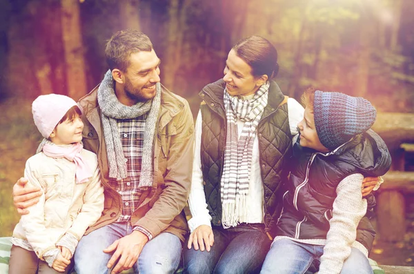 Glückliche Familie sitzt auf Bank und unterhält sich im Lager — Stockfoto