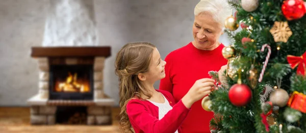 Großmutter und Enkelin am Weihnachtsbaum — Stockfoto