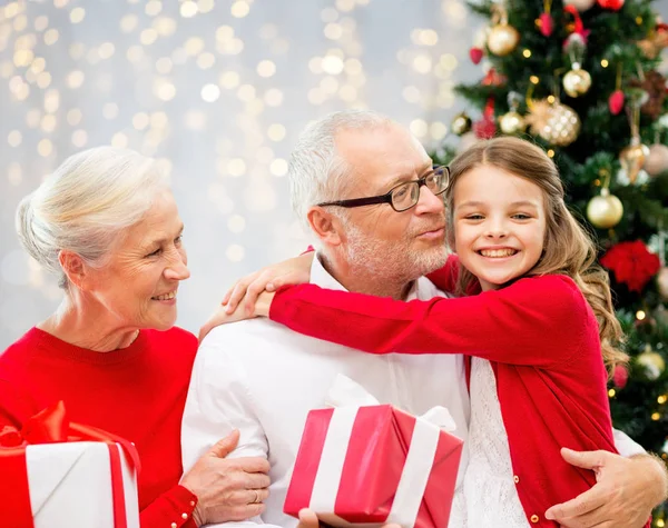 Família feliz com presentes de Natal sobre luzes — Fotografia de Stock