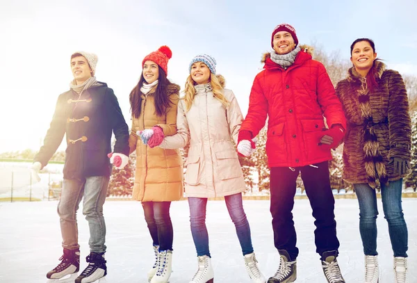 Happy vänner skridskoåkning på isbanan utomhus — Stockfoto