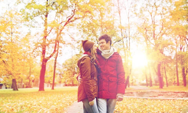 Happy young couple walking in autumn park — Stock Photo, Image