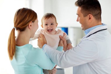 happy woman with baby and doctor at clinic clipart
