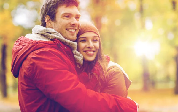 Feliz pareja joven abrazándose en el parque de otoño —  Fotos de Stock