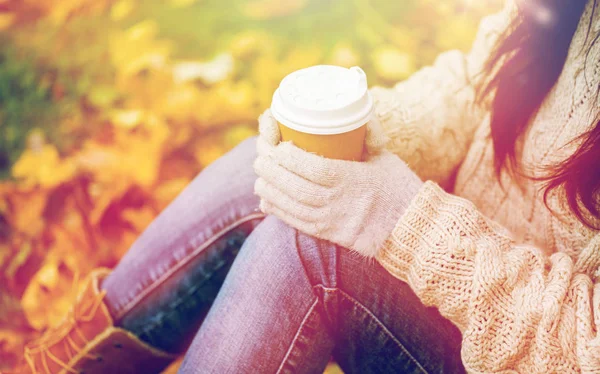 Close up of woman drinking coffee in autumn park — Stock Photo, Image
