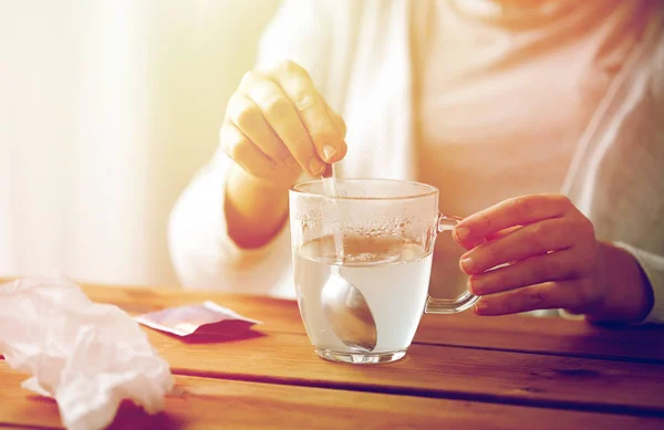 Femme agitant médicament dans une tasse avec cuillère — Photo