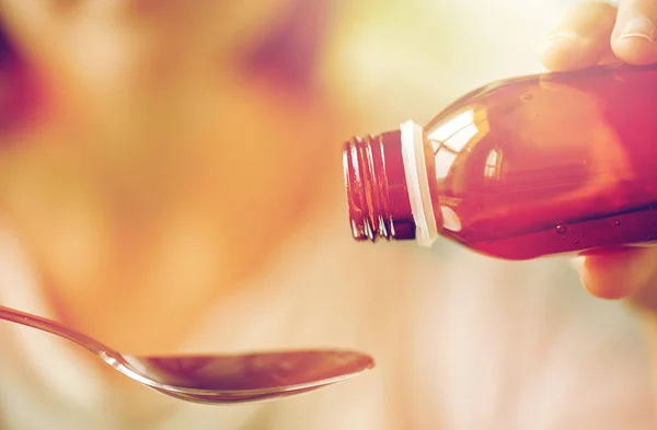 Vrouw gieten medicatie van de fles op de lepel — Stockfoto