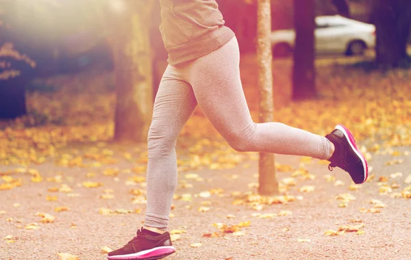 Närbild på ung kvinna kör i höst park — Stockfoto