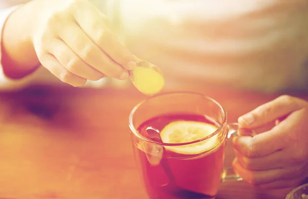 Närbild av kvinna lägga ingefära till te med citron — Stockfoto