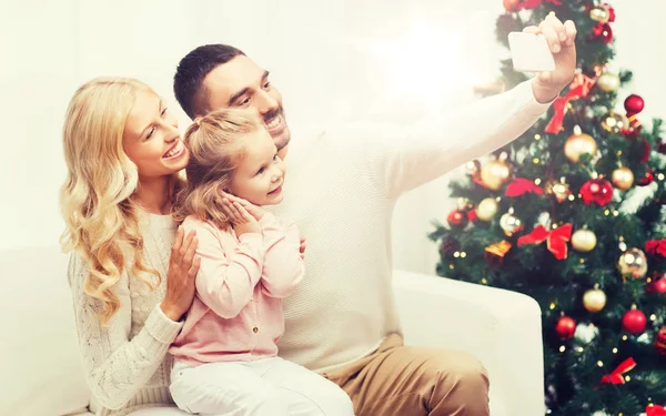 Family taking selfie with smartphone at christmas — Stock Photo, Image