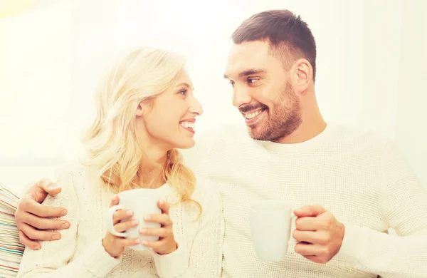 Feliz pareja con tazas de té en casa — Foto de Stock