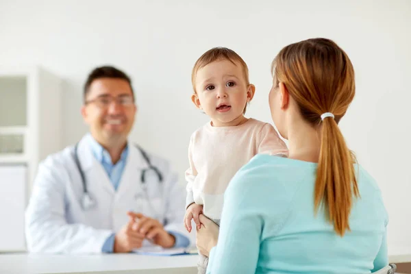 Gelukkige vrouw met baby en arts bij kliniek — Stockfoto