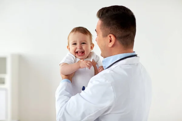 Glücklicher Arzt oder Kinderarzt mit Baby in der Klinik — Stockfoto