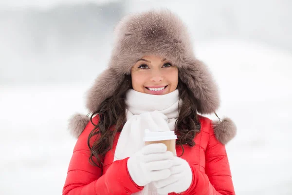 Mujer feliz en sombrero de piel de invierno con café al aire libre — Foto de Stock