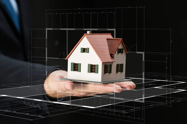 Close up of businessman hand holding house model — Stock Photo, Image