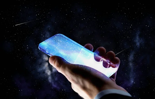 Primer plano de la mano con el teléfono inteligente de vidrio sobre el espacio —  Fotos de Stock