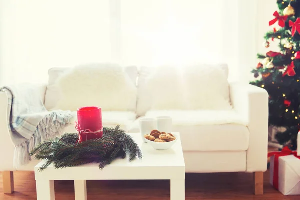 Sofá, mesa e árvore de Natal com presentes em casa — Fotografia de Stock