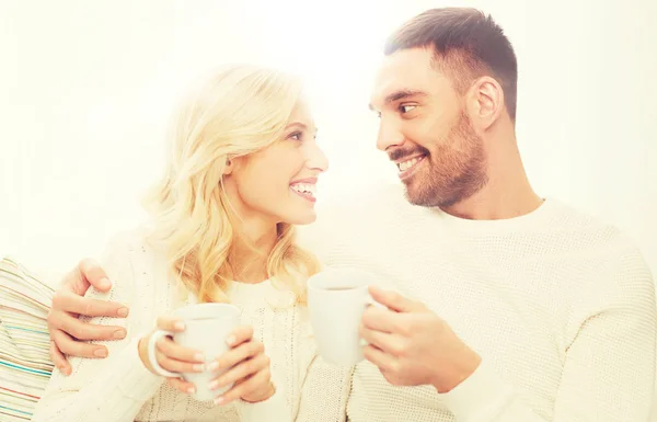 Szczęśliwa para z kubki do picia herbaty w domu — Zdjęcie stockowe