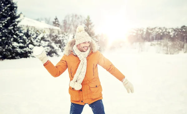 Jovem feliz jogando bolas de neve no inverno — Fotografia de Stock