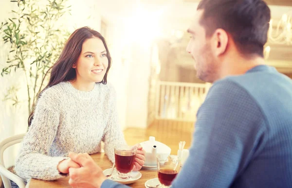 Šťastný pár s čajem drží ruce v restauraci — Stock fotografie