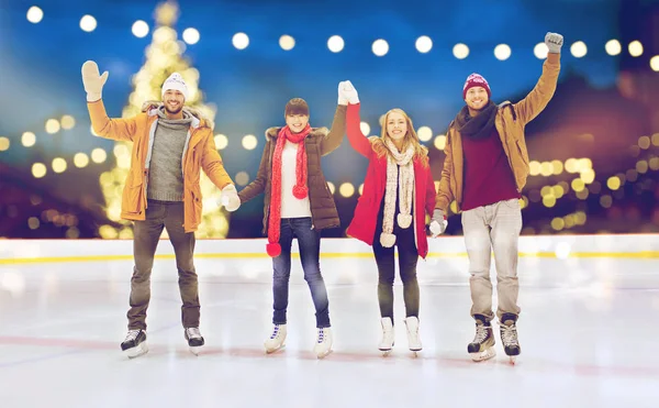 Happy friends waving hands on outdoor skating rink — Stock Photo, Image