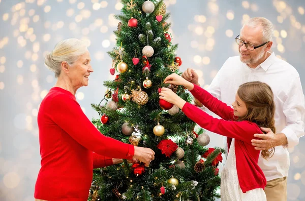 Großeltern und Enkelin am Weihnachtsbaum — Stockfoto
