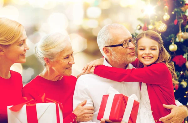 Happy family with christmas gifts over lights — Stock Photo, Image