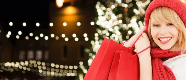 Mulher feliz com sacos de compras sobre a árvore de Natal — Fotografia de Stock