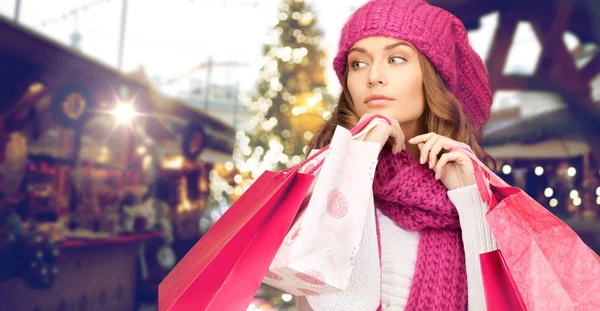 Gelukkige vrouw met boodschappentassen over christmas fair — Stockfoto