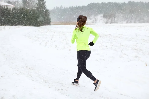 Žena běží venku v zimě — Stock fotografie