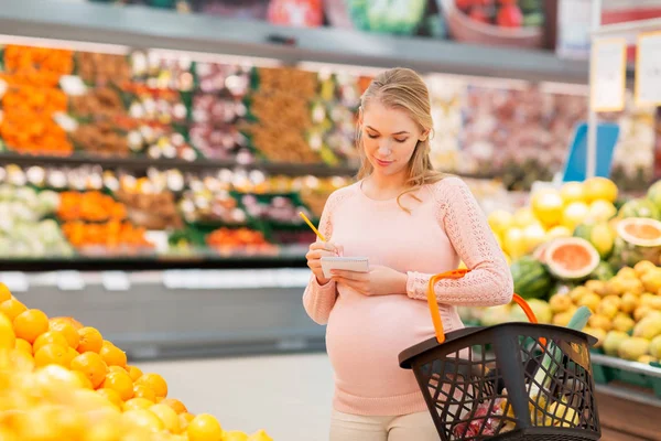 Mulher grávida com cesta de compras no supermercado — Fotografia de Stock