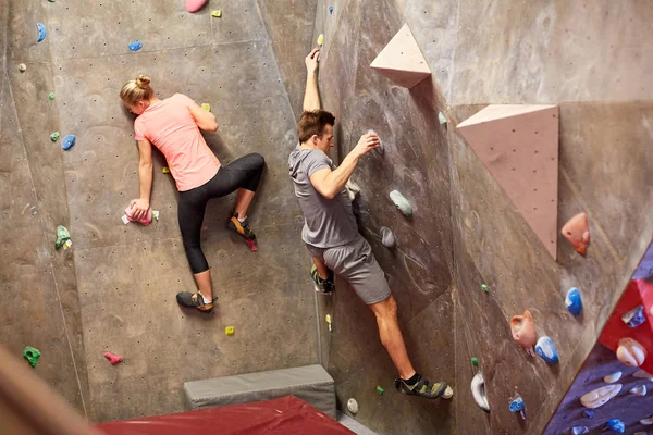 Homem e mulher treinando na parede do ginásio de escalada interior — Fotografia de Stock