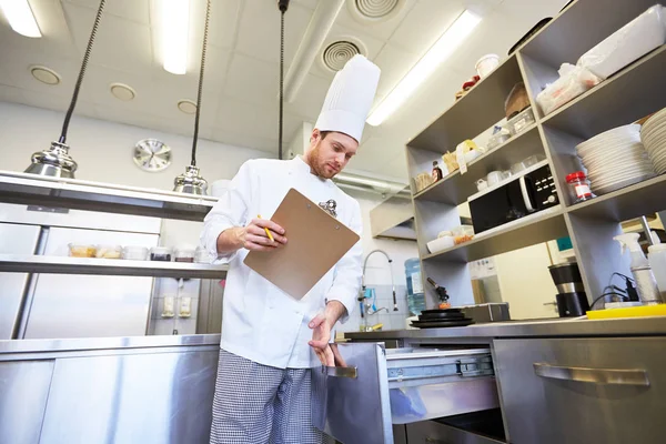 Chef con portapapeles haciendo inventario en la cocina — Foto de Stock